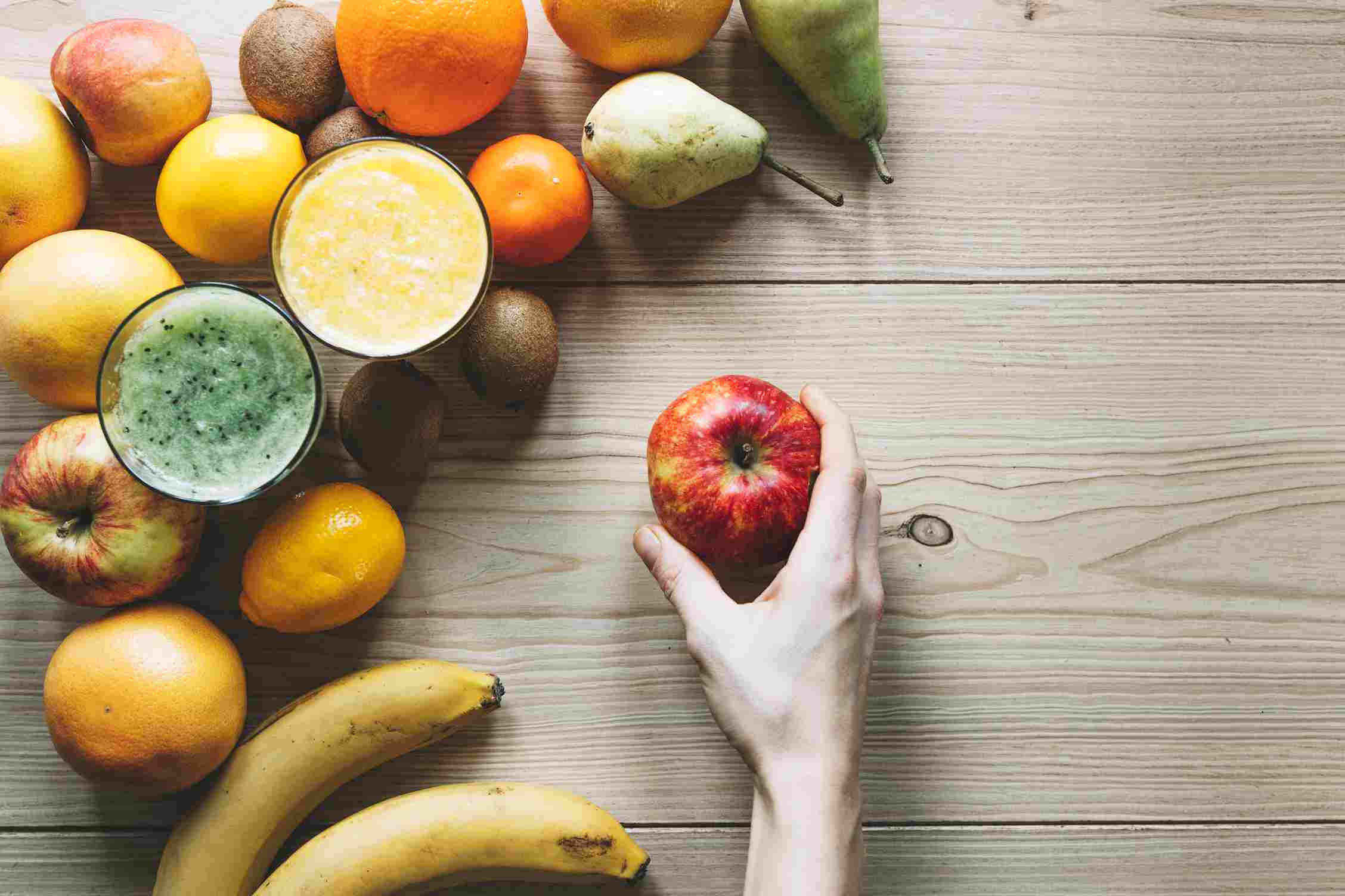 crop-hand-with-apple-near-fruits-smoothie